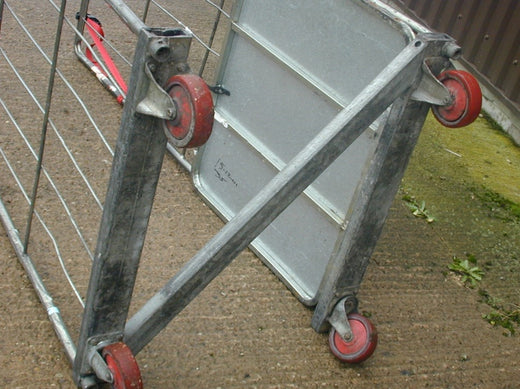 A close-up of worn roll cage wheels representing signs you need to replace your industrial castors