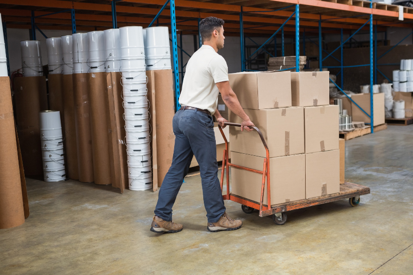 A man pushing an industrial trolley with plate fixing castors